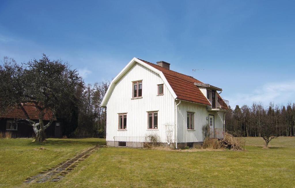 uma casa branca com um telhado vermelho num campo em Amazing Home In Tranemo With Kitchen em Tranemo