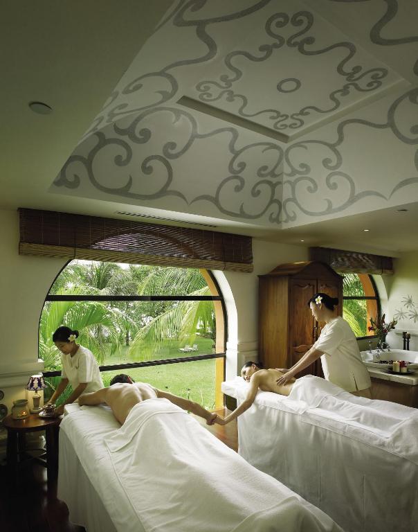 a group of people laying on beds in a room at PARKROYAL Penang Resort in Batu Ferringhi
