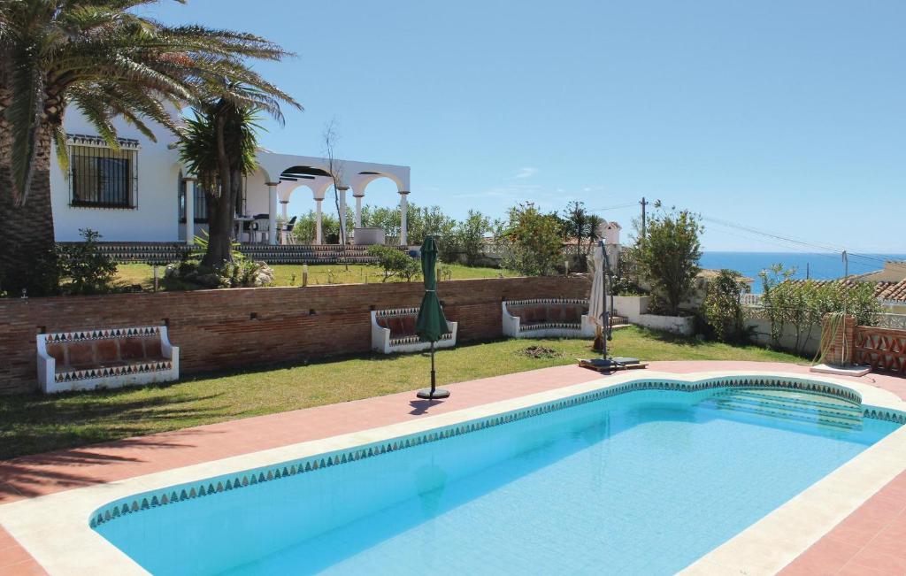 uma piscina em frente a uma casa em Nice Home In Las Farolas With 4 Bedrooms, Wifi And Outdoor Swimming Pool em Mijas Costa