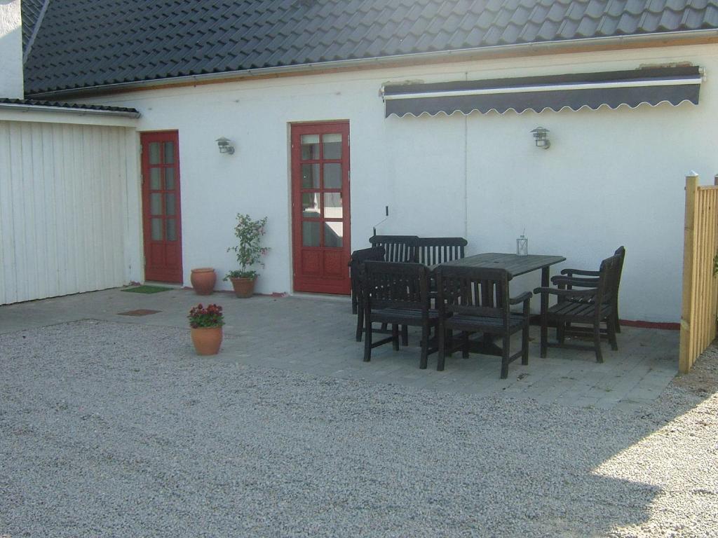 a patio with a table and chairs in front of a building at Skjoldbjerg Garnihotel in Vorbasse