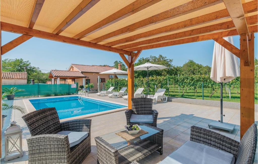 patio z krzesłami i basenem w obiekcie Beautiful Home In Topid With 2 Bedrooms, Wifi And Outdoor Swimming Pool w mieście VeliGolji