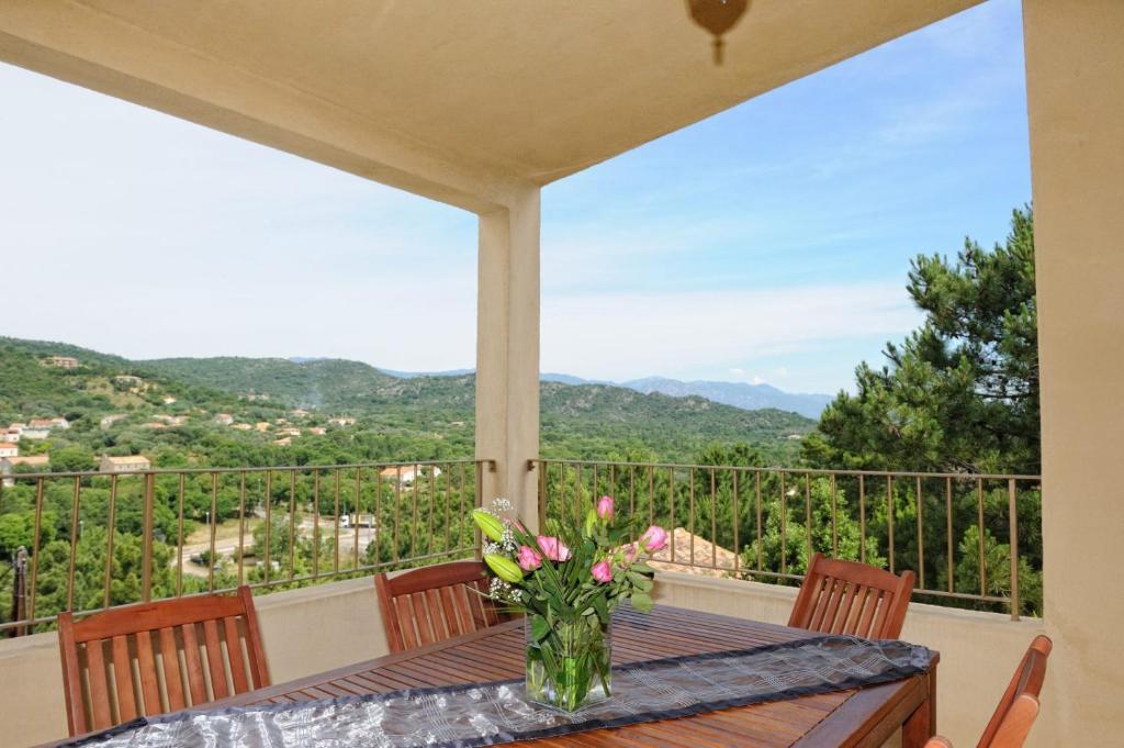 a table with a vase of flowers on a balcony at Fiori Di Santa Giulia in Porto-Vecchio