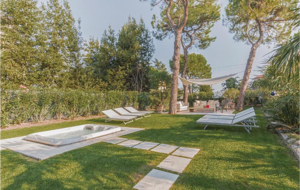 デセンツァーノ・デル・ガルダにあるCasa Romanticaの芝生の中にベンチ2台とハンモックが備わる庭園