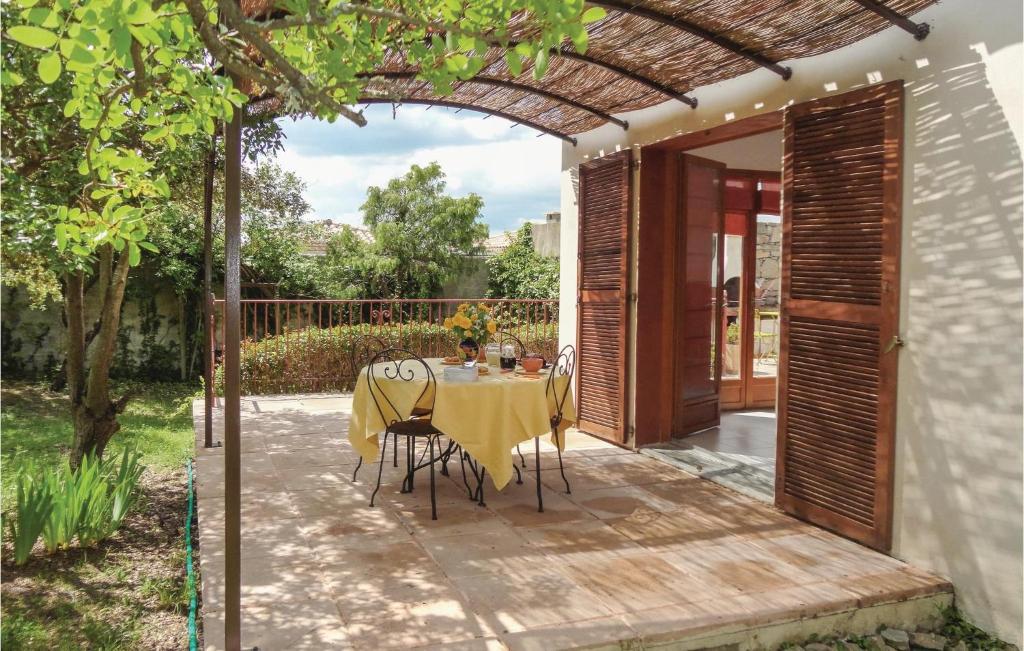 patio ze stołem i krzesłami pod pergolą w obiekcie Lovely Home In Cazevieille With Kitchen w mieście Cazevieille