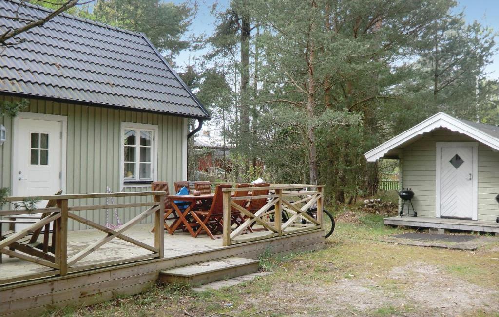 ベーダにあるAmazing Home In Lttorp With Kitchenの木製の柵とテーブルのある小さな緑の家