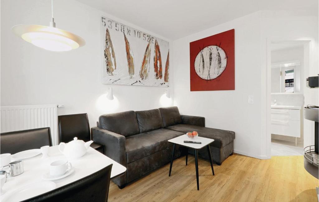 トラフェミュンデにある1 Bedroom Amazing Apartment In Lbeck Travemndeのリビングルーム(ソファ、テーブル付)