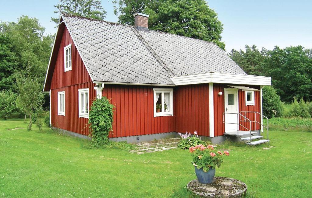 a red house in a yard with a green field at Gorgeous Home In Vxtorp With Kitchen in Floalt
