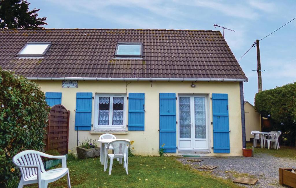 ein kleines Haus mit blauen Türen und weißen Stühlen in der Unterkunft 2 Bedroom Amazing Home In Anneville Sur Mer in Anneville-sur-Mer