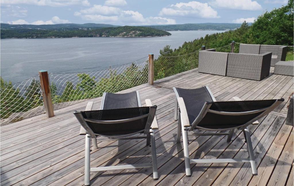 dwa krzesła na tarasie z widokiem na wodę w obiekcie Gorgeous Home In Nordre Frogn With House Sea View w mieście Båtstø