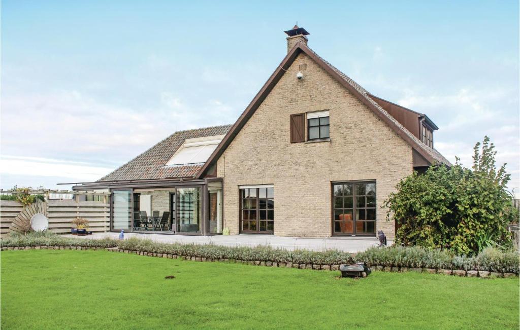 een groot bakstenen huis met een grasveld bij 4 Bedroom Gorgeous Home In Groede in Groede