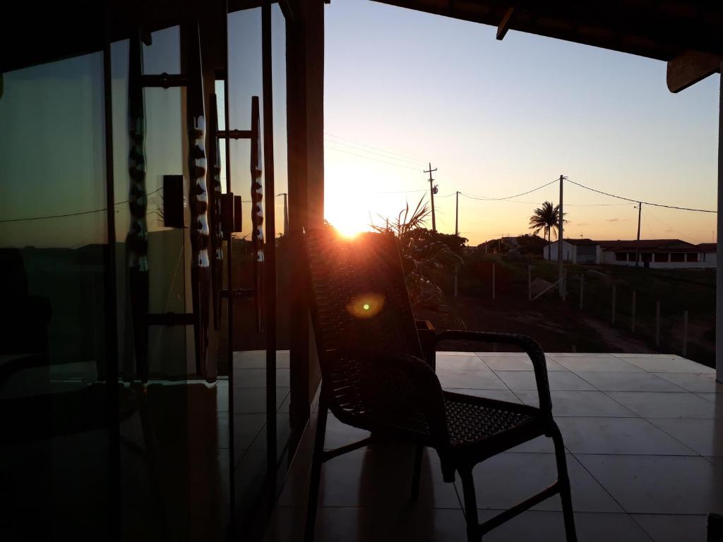 einen Stuhl auf einer Veranda mit Sonnenuntergang in der Unterkunft Cantinho Serrano in Serra de São Bento