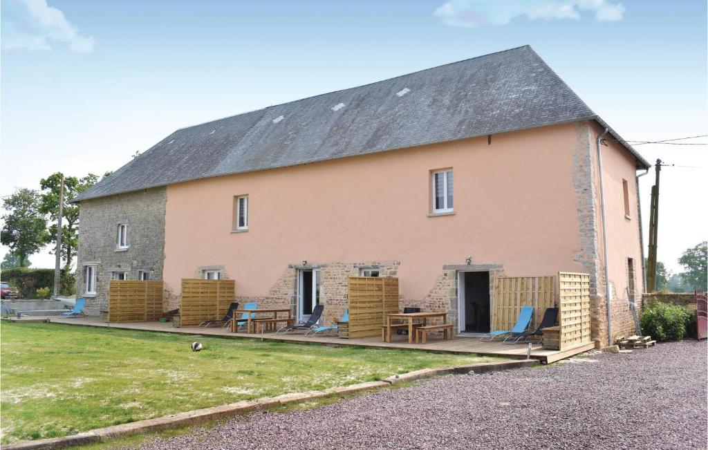 a barn with chairs and tables on the porch at 1 Bedroom Cozy Apartment In Sainteny in Sainteny