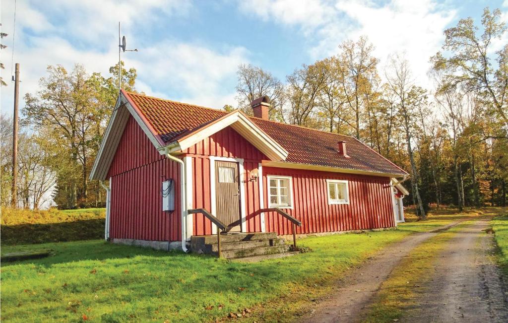 une petite maison rouge sur le côté d'un chemin de terre dans l'établissement Amazing Home In Hstveda With Wifi, à Hästveda