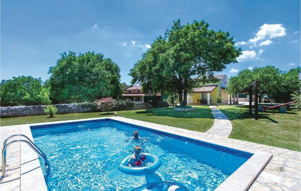 een persoon in een zwembad in een achtertuin bij Nice Home In Badnjevari With Wifi in Benčići