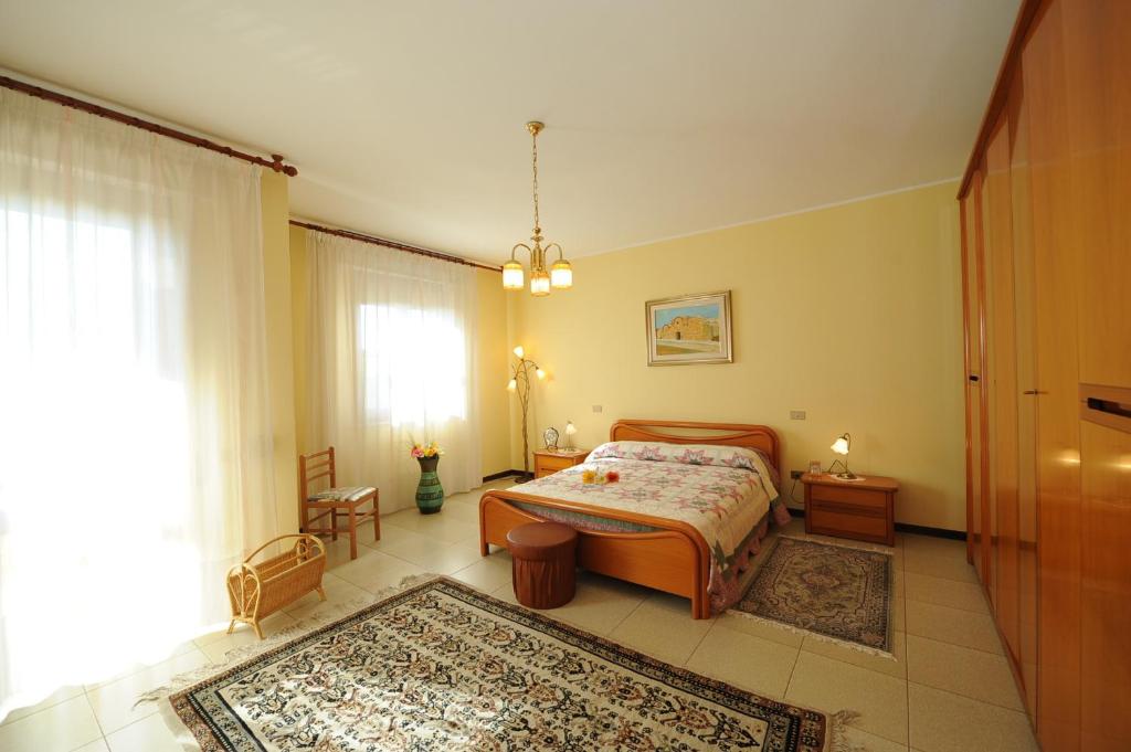 a bedroom with a bed and a large window at B&B Su Fassoi in Santa Giusta