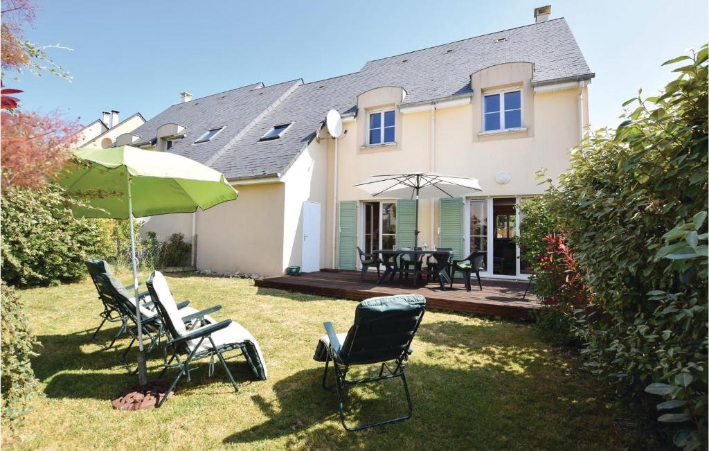 a house with chairs and umbrellas in the yard at 4 Bedroom Cozy Home In Port-en-bessin-huppain in Huppain
