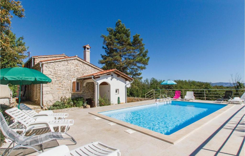 a villa with a swimming pool and patio furniture at Pet Friendly Home In Martinjski With Kitchen in Martinski