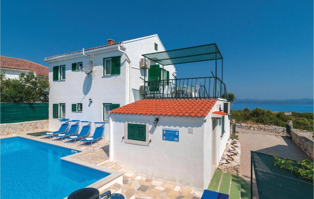a white house with a swimming pool next to the ocean at Beautiful Home In Rogac With House Sea View in Rogač