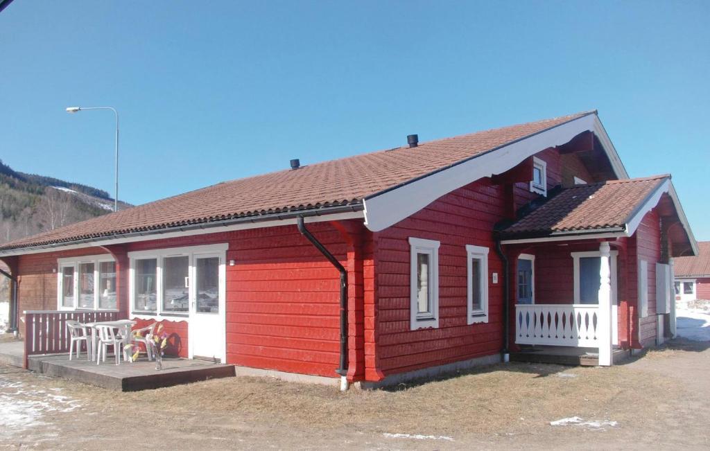 una pequeña casa roja con una mesa delante en 3 Bedroom Awesome Home In Sysslebck, en Branäs