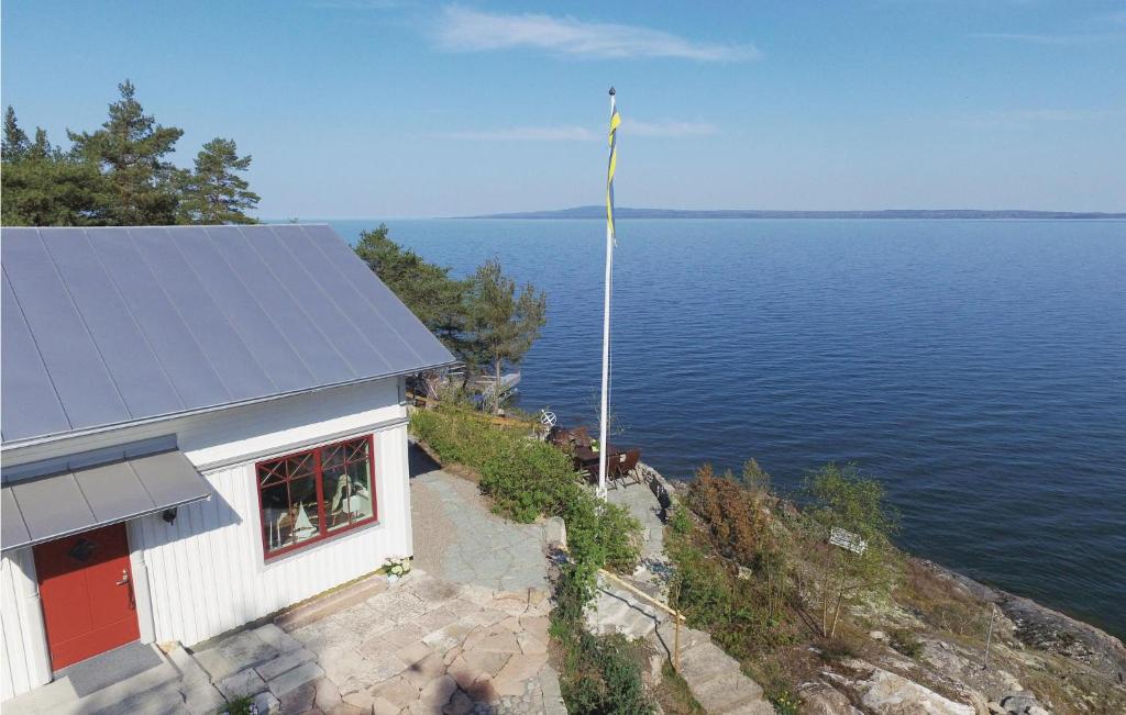 um edifício com um mastro de bandeira junto à água em Nice Home In Lidkping With Kitchen em Lidköping