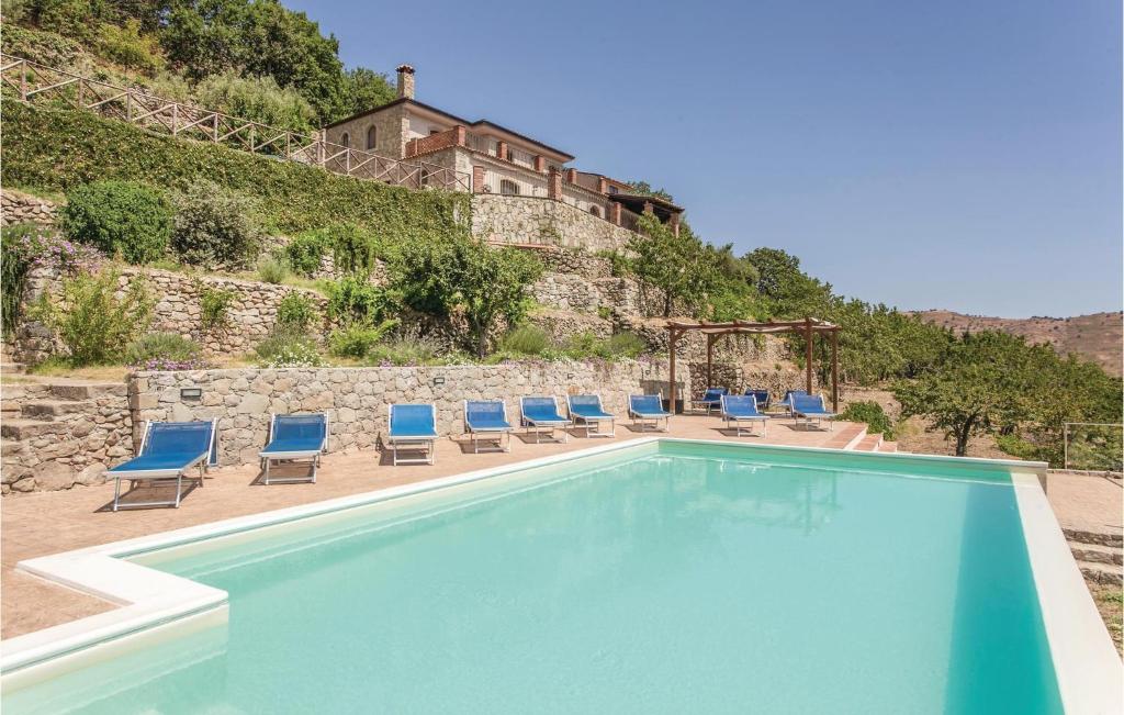 a swimming pool with chairs and a building in the background at Marianna in Graniti