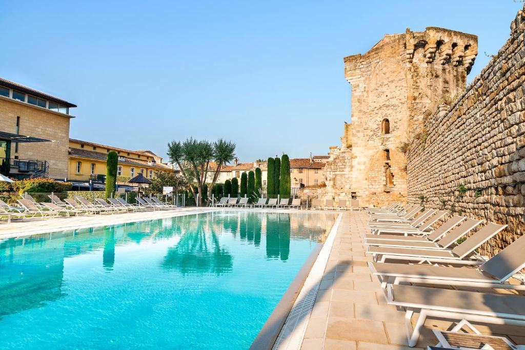 a large swimming pool with a balcony overlooking a city at Aquabella Hôtel & Spa in Aix-en-Provence