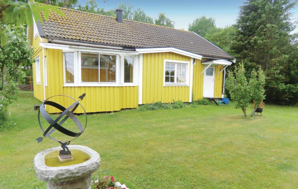 a yellow house with a statue in front of it at Stunning Home In Lttorp With 2 Bedrooms in Löttorp