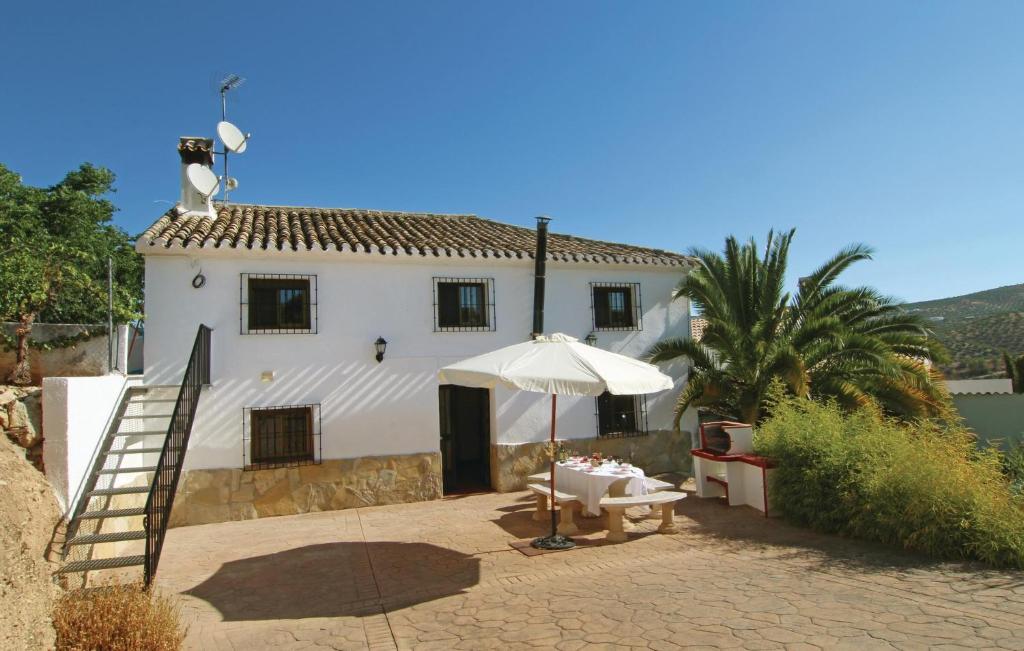 a white house with a ladder and an umbrella at Beautiful Home In Sileras-almedinilla With Kitchenette in Almedinilla