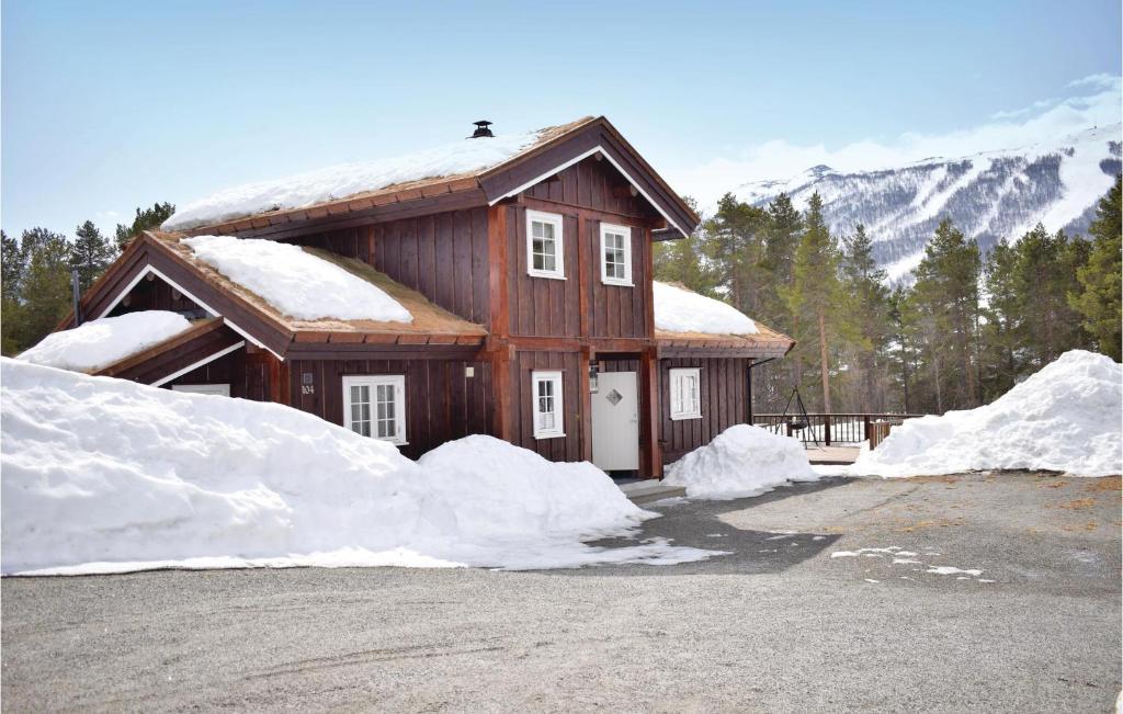 a house with snow piled up in front of it at Three-Bedroom Holiday Home In Hovet in Hovet