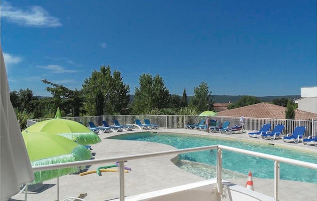 モントルーにあるBeautiful Home In Montauroux With 2 Bedrooms, Outdoor Swimming Pool And Heated Swimming Poolのパラソルと椅子付きのスイミングプール、スイミングプール