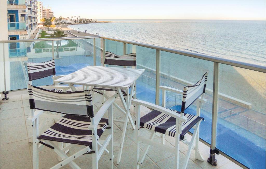 einen Tisch und Stühle auf einem Balkon mit Meerblick in der Unterkunft Amazing Apartment In La Manga Del Mar Menor With Kitchen in San Blas