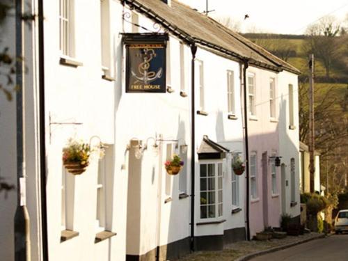 un edificio blanco con un cartel en el costado en The Anchor Inn, en Ivybridge