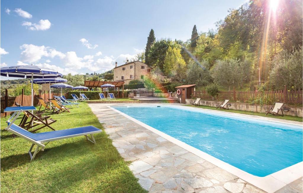 uma piscina num quintal com cadeiras e guarda-sóis em Stunning Apartment In Prato Dera Pi With 1 Bedrooms, Wifi And Outdoor Swimming Pool em Ulignano