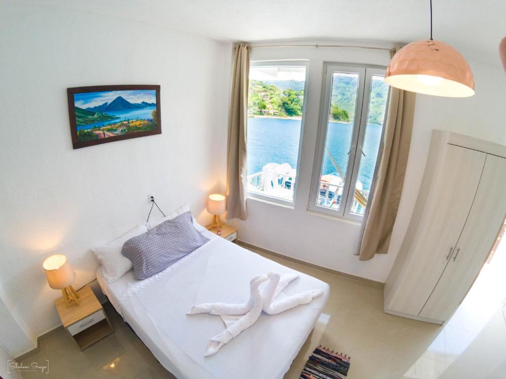 a room with a bed and a large window at San Pedro Suite in San Pedro La Laguna