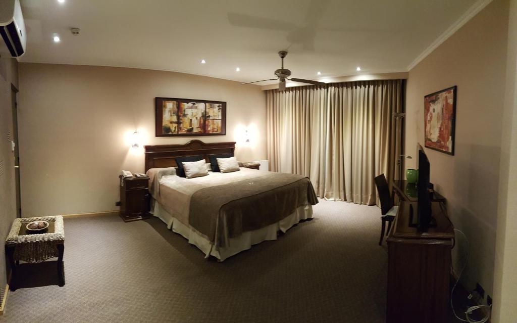 サンフアンにあるHotel Viñas del Solのベッドとテレビが備わるホテルルームです。