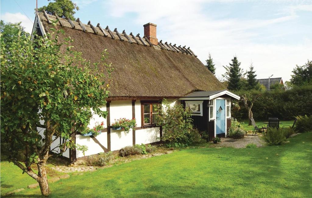 een huisje met een rieten dak en een tuin bij Nice Home In Kvidinge With Wifi in Kvidinge