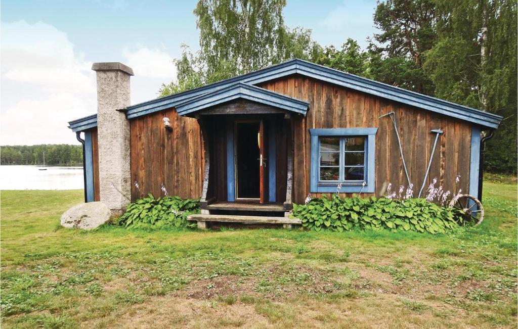 Cabaña de madera pequeña con puerta y ventana en Beautiful Home In Frseke With House Sea View, en Fröseke