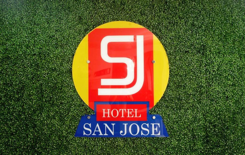 una señal para un hotel en la hierba en Hotel San José en San José
