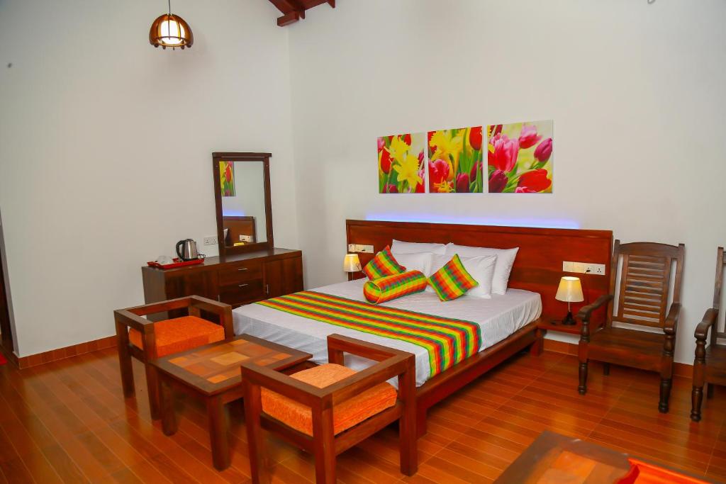 a bedroom with a bed and a table and chairs at Heaven in Satinwoods in Tangalle