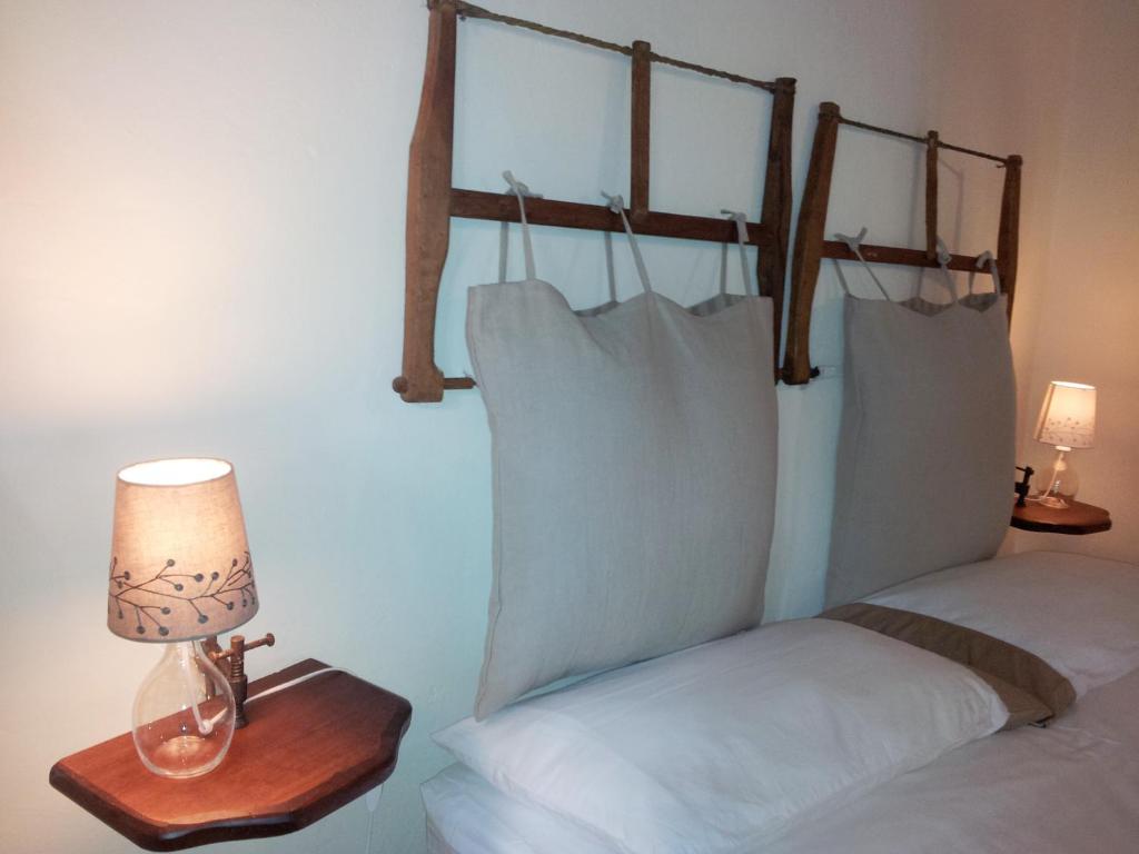 a bed with white pillows and a lamp on a table at Le Residenze Ristori in Cortona