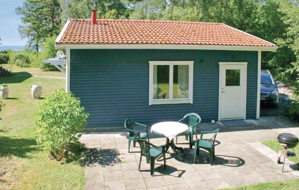a small blue house with a table and chairs at Stunning Home In Frjestaden With 2 Bedrooms And Wifi in Färjestaden