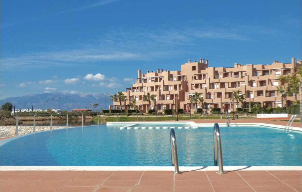 uma grande piscina em frente a um grande edifício em 2 Bedroom Pet Friendly Apartment In Alhama De Murcia em El Romero