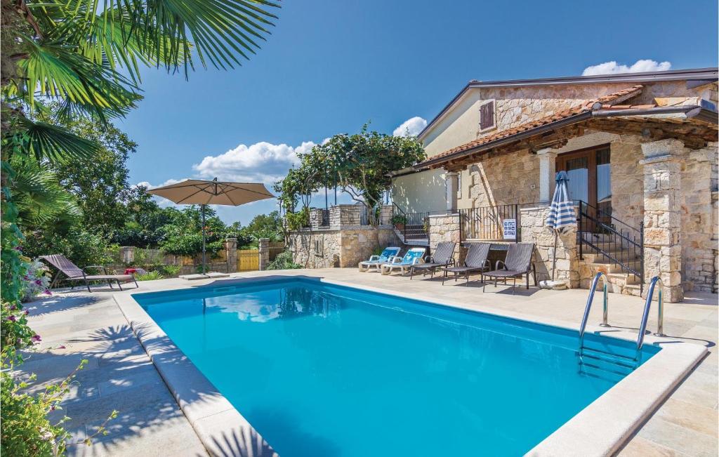 a swimming pool in front of a villa at 4 Bedroom Cozy Home In Puzari in Pićan