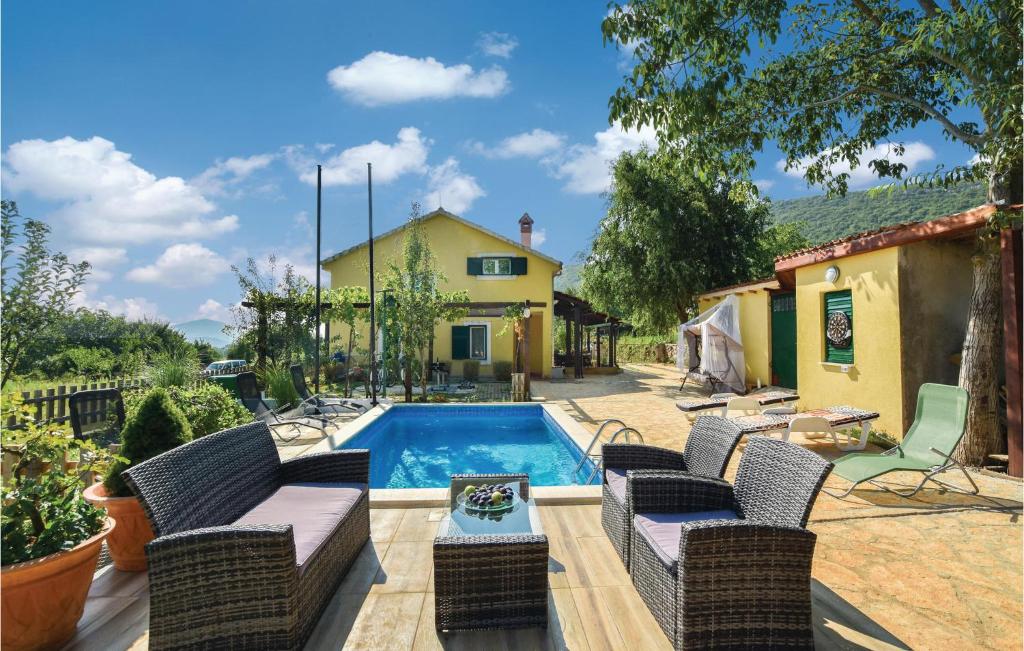 un cortile con piscina, sedie e una casa di Gorgeous Home In Dicmo With Outdoor Swimming Pool a Jadrići