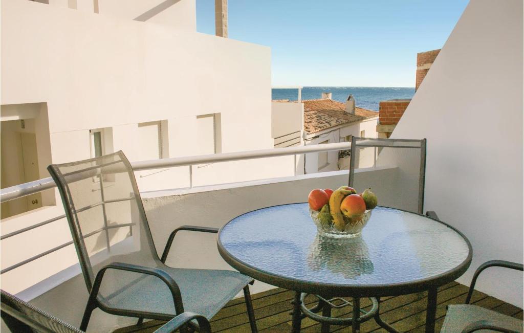 einen Tisch und Stühle auf einem Balkon mit einer Obstschale in der Unterkunft Nice Apartment In Casarones With Kitchen in Castillo de BaÃ±os