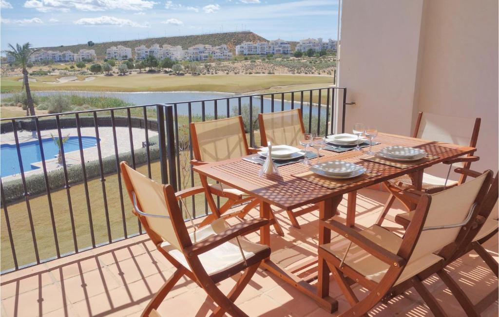een houten tafel en stoelen op een balkon met uitzicht bij Hacienda Riquelme in Sucina