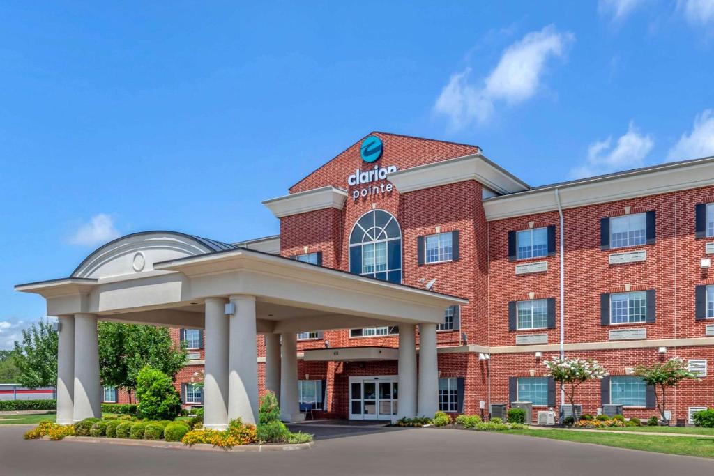 un edificio de ladrillo rojo con un cenador frente a él en Clarion Pointe Sulphur Springs, en Sulphur Springs