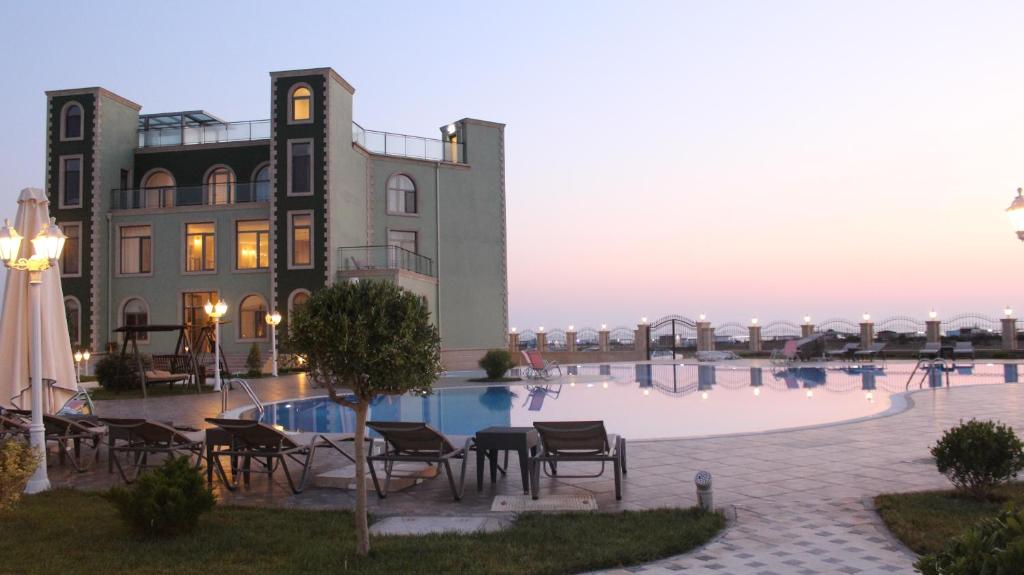 a large building with a pool in front of a building at Khazar Inji in Baku