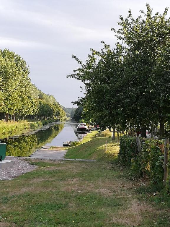 a river with a car parked on the side at La maison de la Vallée in Froissy