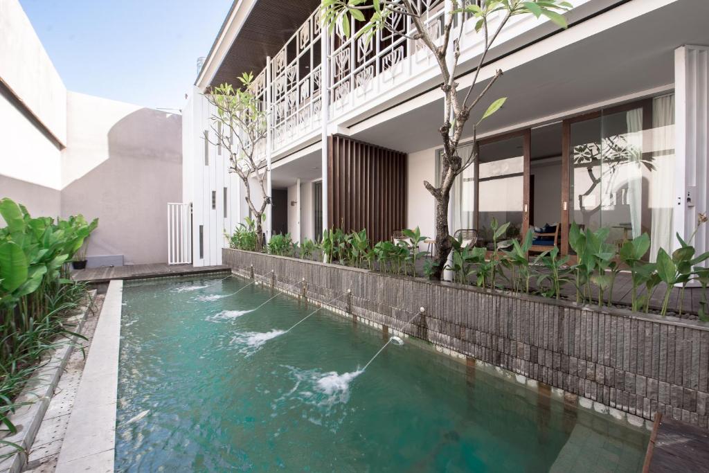 a swimming pool in front of a house at Pelangi 148 in Seminyak